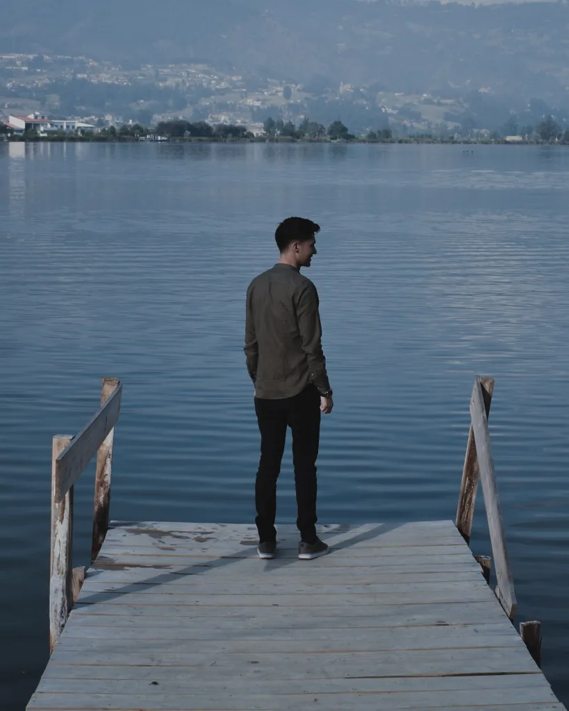 rear-view-man-standing-pier-lake
